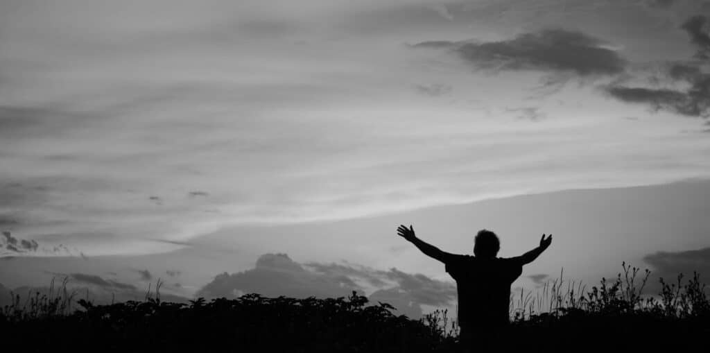 Man holding arms up in praise Glory Be Prayer